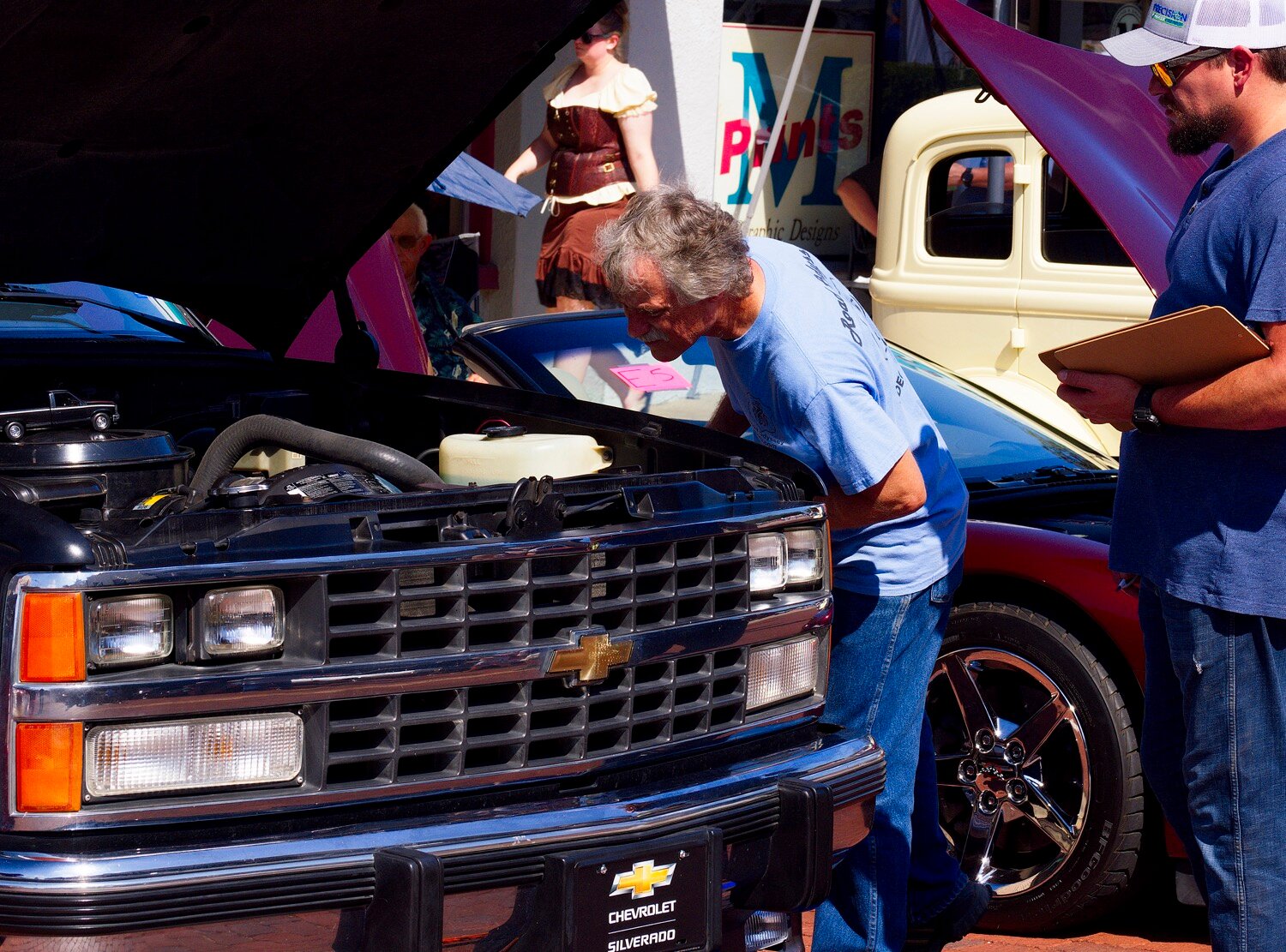 A judge takes a look under the hood of a Chevy Silverado. [additional iron horse images available]